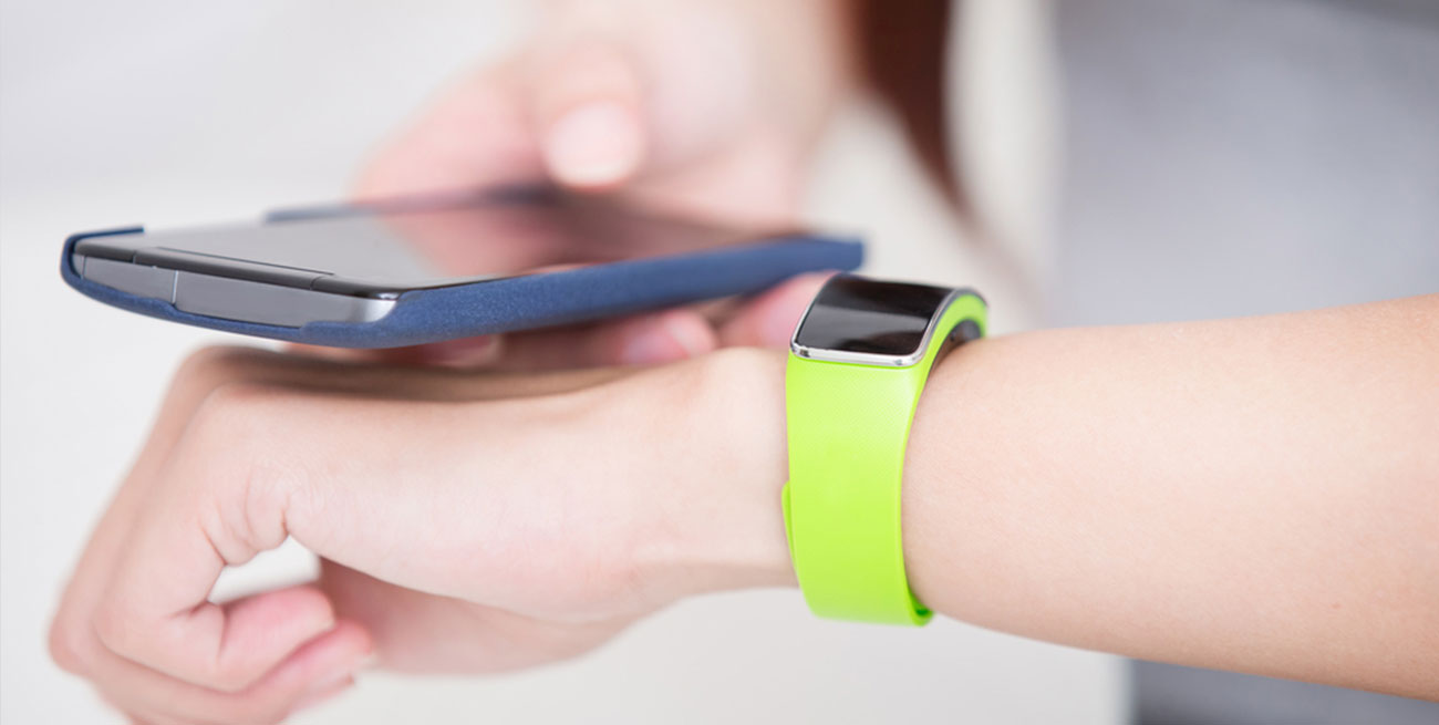 Mulher sincroniza smartwatch com smartphone