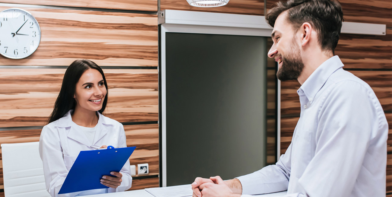 Recepcionista atendendo paciente em consultório